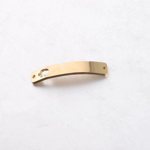 Detail of a curved golden stainless steel jewelry connector with unique cutout design