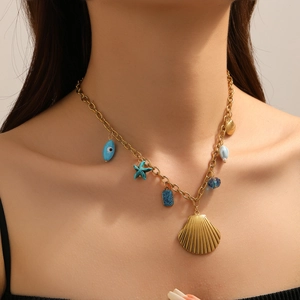 Detail der Goldkette mit Muschelanhängern und blauen Perlen-Seestern-Anhängern am Hals