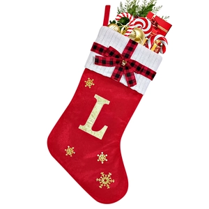 Detail of red velvet Christmas stocking with white knit cuff and gold glitter letter L