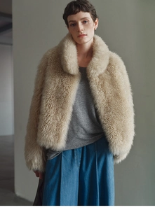 Detail of beige faux fox fur cashmere vest showing fluffy texture and soft curly wool