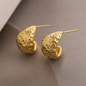 Macro shot of gold-plated heart earrings with unique hammered texture and C-shape design