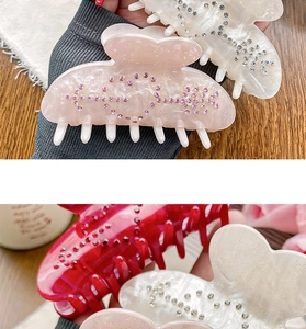 Détail de la pince à cheveux cœur avec strass roses et cristaux sur monture en acétate