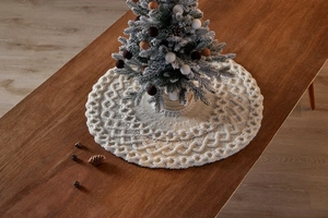 Détail du tapis de sapin de Noël en tricot torsadé crème avec des textures décoratives