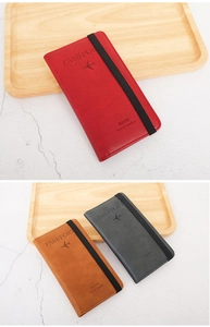 Close-up of leather RFID passport wallets in red, brown, and gray with elastic straps