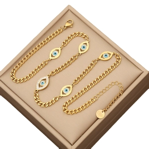 Gold stainless steel Cuban link bracelet with iced out evil eye charms in a gift box
