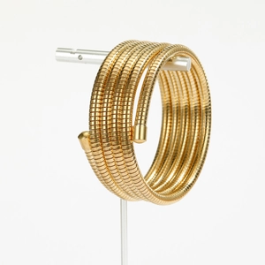 Detailed view of golden multi-layer spiral spring bracelet on a silver display stand