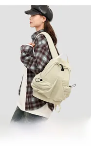 Detail of beige nylon space-themed backpack with side pockets and drawstring accents
