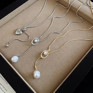 Three elegant adjustable heart and pearl necklaces on a brown velvet jewelry tray