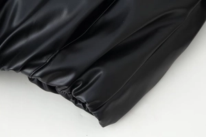 Macro della trama della pelle nera con polsino plissettato e dettagli della cerniera