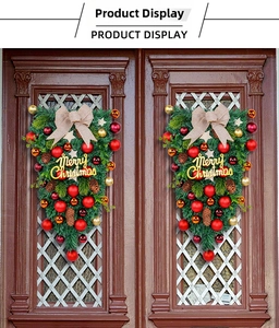 Detail of Christmas teardrop swag with pine needles, ornaments, and burlap bow on door