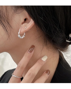 Close-up of S925 sterling silver rope circle earrings and engraved ring set on model