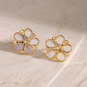 Detail of flower stud earrings with gold finish and purple stone petals in macro view