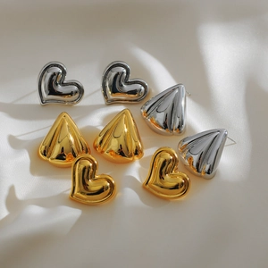 Vintage gold and silver heart and geometric stud earrings set on white silk