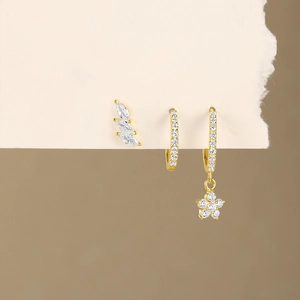 Detail of three gold S925 silver earrings set with sparkling zircon crystal studs