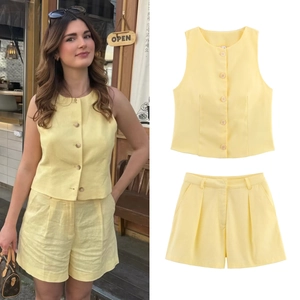 Detalle de conjunto amarillo claro de algodón y lino mostrando textura de chaleco y shorts