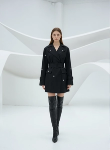 Détail d'une robe noire à double boutonnage avec boutons argentés et ceinture taille