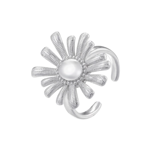 Macro detail of silver sunflower ring with textured petals and center pearl accent