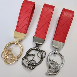 Detail of red embossed leather keychains with gold, silver and gunmetal zinc alloy hooks