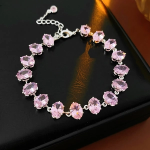 Macro detail of oval pink zirconia bracelet with silver claw settings on black leather