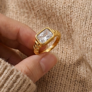 Macro detail of a vintage gold twisted ring featuring a large rectangular clear stone