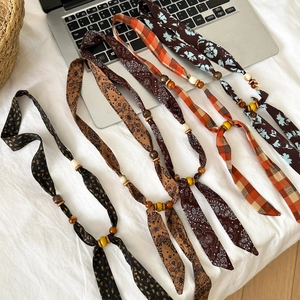 Flat lay of bohemian chiffon fabric necklaces with wooden beads in various patterns