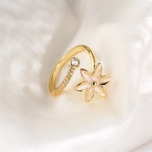 Vue macro détaillée de la bague ouverte dorée avec fleurs en émail rose et zircons