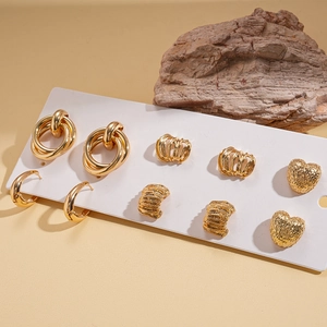 Detail view of 10-piece gold earring set with geometric heart shapes on stone display