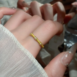 Macro shot of gold bamboo joint ring with matte texture and sparkling zircon accents