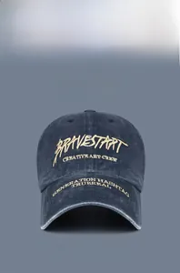 Detailed close-up of retro washed cotton baseball cap with gold 3D embroidery and stitching