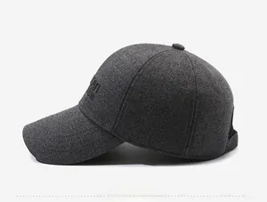 Detail view of dark grey knit baseball cap featuring side embroidery and ear protection