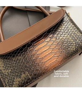 Close-up of retro brown faux crocodile skin texture and metallic buckle on handbag