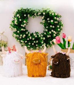 Detailed display of Highland Cow plush toys in white, orange, and brown with flower crowns