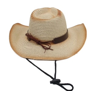 Détail de la texture du chapeau de paille tressé avec ruban en cuir et cordon coupe-vent