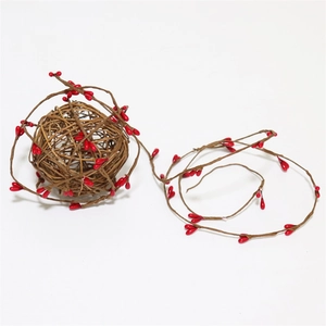 Détail de la guirlande de baies rouges et boule de rotin pour décoration de Noël