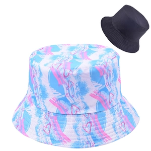Detail of a reversible bucket hat featuring pink heart prints and a blue texture design