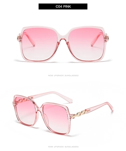 Close-up of pink gradient lenses and gold chain link detail on square sunglasses