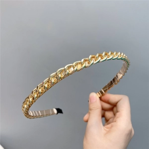 Detailed view of the golden metal chain headband with protective tips and sleek texture