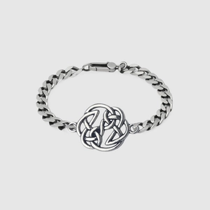 Silver Celtic knot charm on a polished curb chain bracelet with secure lobster clasp