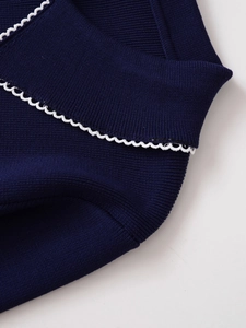 Detail eines dunkelblauen Strickpullovers mit weißem Wellenrand und Rippenstruktur am Kragen