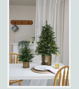Close-up of mini glowing green Christmas trees on a festive dining table setting