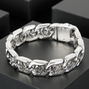 Macro shot of silver metal punk bracelet with cross cut-outs and bold chain links
