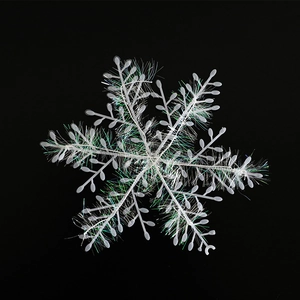 White Christmas snowflake hanging ornament with iridescent wire detail on black background