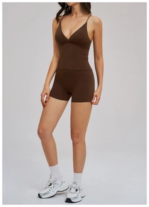 Detail of dark brown yoga set featuring a deep V-neck camisole and matte cycling shorts