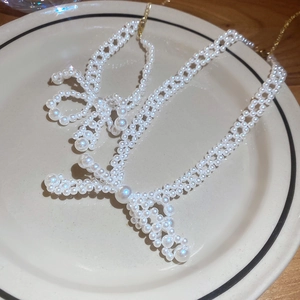 Disposition artistique d'un collier de perles en forme de nœud avec chaîne dorée