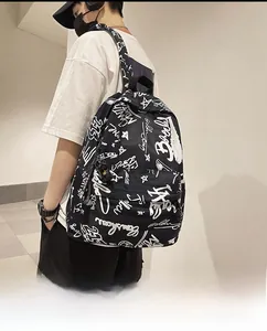 Close-up of black backpack featuring white hand-drawn graffiti patterns and stars
