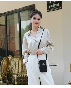 Gros plan du mini sac à bandoulière en nylon noir avec sangle réglable sur un mannequin