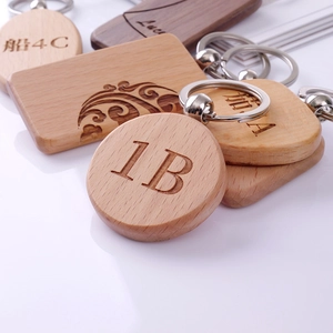 Custom engraved wooden zodiac keychains in various shapes on a clean white surface