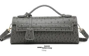 Detailed macro view of the ostrich texture and golden buckle on gray baguette bag