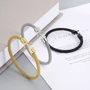 Makroaufnahme von Ankerverschluss an geflochtenen Netzarmbändern in Gold, Silber, Schwarz