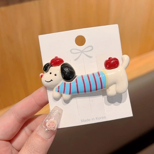 Detail of cute dachshund hair clip in white sweater and red beret on a card